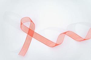 conciencia de la cinta roja de primer plano sobre fondo blanco para la campaña del día mundial del sida. concepto de salud y medicina. foto