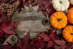 Festive autumn decor from pumpkins, pine and leaves on a  wooden background. Concept of Thanksgiving day or Halloween. Flat lay autumn composition with copy space.