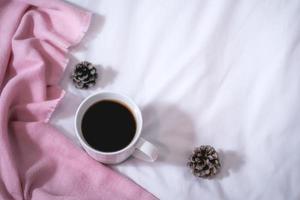 Christmas composition. Cup of coffee, scarf on pink background. Christmas, winter concept. Flat lay, top view, copy space photo