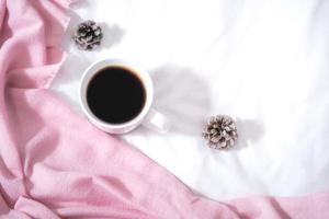 Christmas composition. Cup of coffee, scarf on pink background. Christmas, winter concept. Flat lay, top view, copy space photo