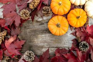 Festive autumn decor from pumpkins, pine and leaves on a  wooden background. Concept of Thanksgiving day or Halloween. Flat lay autumn composition with copy space. photo
