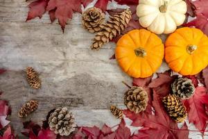 Festive autumn decor from pumpkins, pine and leaves on a  wooden background. Concept of Thanksgiving day or Halloween. Flat lay autumn composition with copy space. photo