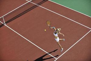 mujer joven jugar al tenis al aire libre foto