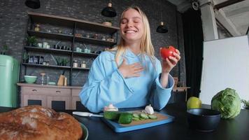 jeune femme dans une cuisine avec des ingrédients frais et un smartphone video