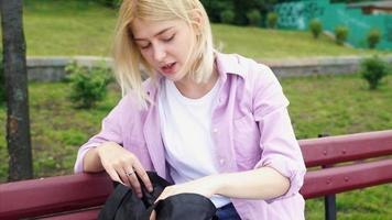 Girl sitting at park bench video