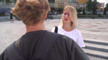 dos jóvenes adolescentes hablan entre sí afuera con mochilas video