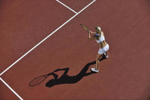 mujer joven jugar al tenis al aire libre foto