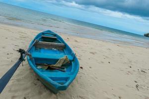 fisherman boat on the Beautiful beach in the morning with rain cloud. photo