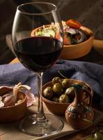 A glass of wine on a table with dishes photo