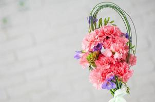 A closeup of a beautiful composition with pink spray carnations and freesia isolated on a white background photo