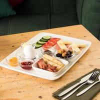 A closeup shot of a breakfast white plate on a wooden table photo