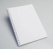 An angle shot of an open blank notebook on a white background with copy space. photo