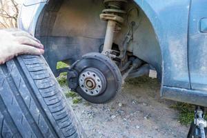 cambiar un neumático de automóvil pinchado en la carretera con mantenimiento de neumáticos, neumático de automóvil dañado foto