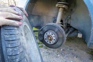 cambiar un neumático de automóvil pinchado en la carretera con mantenimiento de neumáticos, neumático de automóvil dañado foto