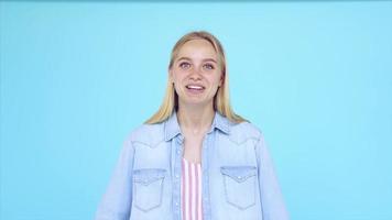 Young blonde woman in front of a light blue backdrop expresses different emotions video