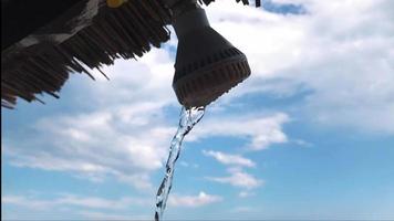 gouttes d'eau de la douche extérieure par une journée ensoleillée bleue video