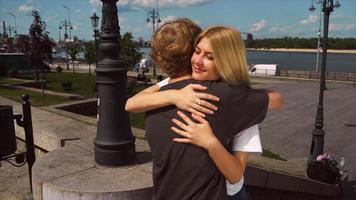 jong meisje en jongen hebben een knuffel Aan een zonnig middag in een stad park video