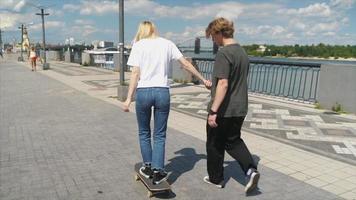 Two young people practice skateboarding on flat concrete between steps video