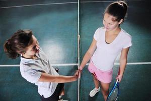 young girls playing tennis game indoor photo