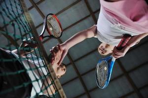 young girls playing tennis game indoor photo