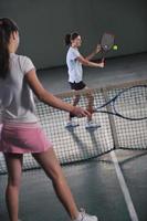 young girls playing tennis game indoor photo