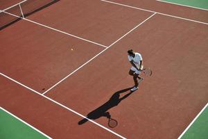 joven jugar al tenis al aire libre foto