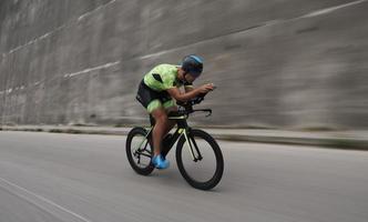 atleta de triatlón montando en bicicleta en el entrenamiento matutino foto