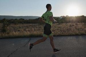 atleta de triatlón corriendo en el entrenamiento matutino foto