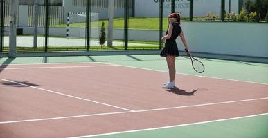 young woman play tennis game outdoor photo