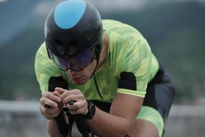 atleta de triatlón montando en bicicleta en el entrenamiento matutino foto