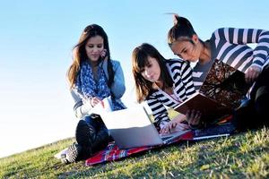 group of teens working on laptop outdoor photo