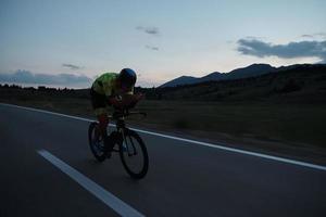 triathlon athlete riding bike at night photo