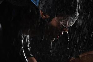 triathlon athlete riding bike  fast on rainy night photo