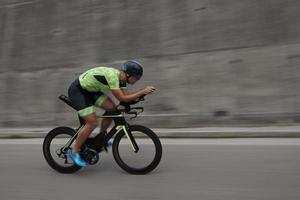 atleta de triatlón montando en bicicleta en el entrenamiento matutino foto