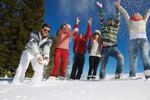 los amigos se divierten en invierno con nieve fresca foto