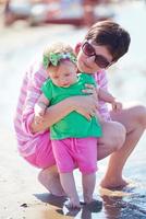 mamá y bebé en la playa se divierten foto