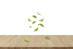 hojas verdes giratorias voladoras en el aire con mesa de madera, productos saludables por concepto de ingredientes naturales orgánicos, espacio vacío en una toma de estudio aislada en una pancarta larga de fondo blanco foto