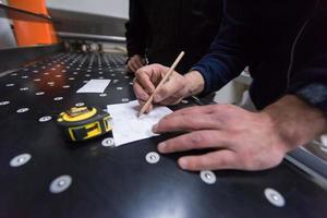 carpenters calculating and programming a cnc wood working machine photo