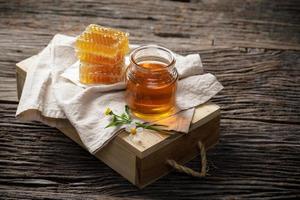 abeja de miel en tarro y panal con flor en mesa de madera, productos de abeja por concepto de ingredientes naturales orgánicos, espacio de copia para su texto foto