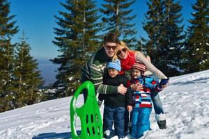 family having fun on fresh snow at winter vacation photo