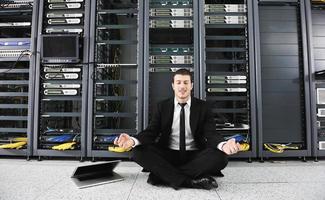 businessman with laptop in network server room photo