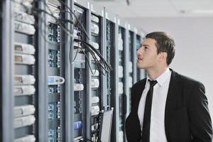 young engeneer in datacenter server room photo