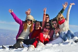 los amigos se divierten en invierno con nieve fresca foto