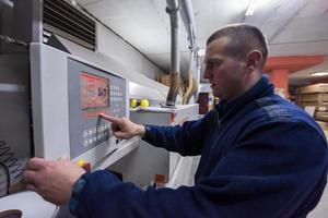 carpintero calculando y programando una máquina de trabajo de madera cnc foto