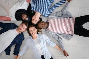 top view of a diverse group of people lying on the floor and symbolizing togetherness photo