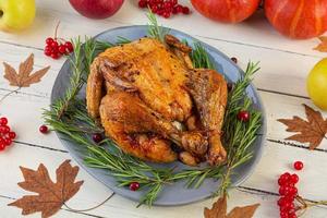 Baked whole chicken or turkey. Roasted homemade chicken with herbs. Thanksgiving day decoration photo