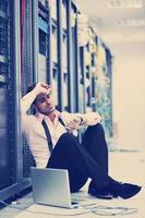 businessman with laptop in network server room photo