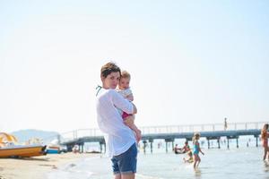 mamá y bebé en la playa se divierten foto