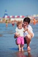 mamá y bebé en la playa se divierten foto