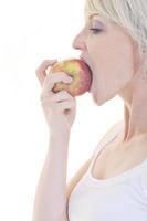 mujer joven feliz comer manzana aislado en blanco foto